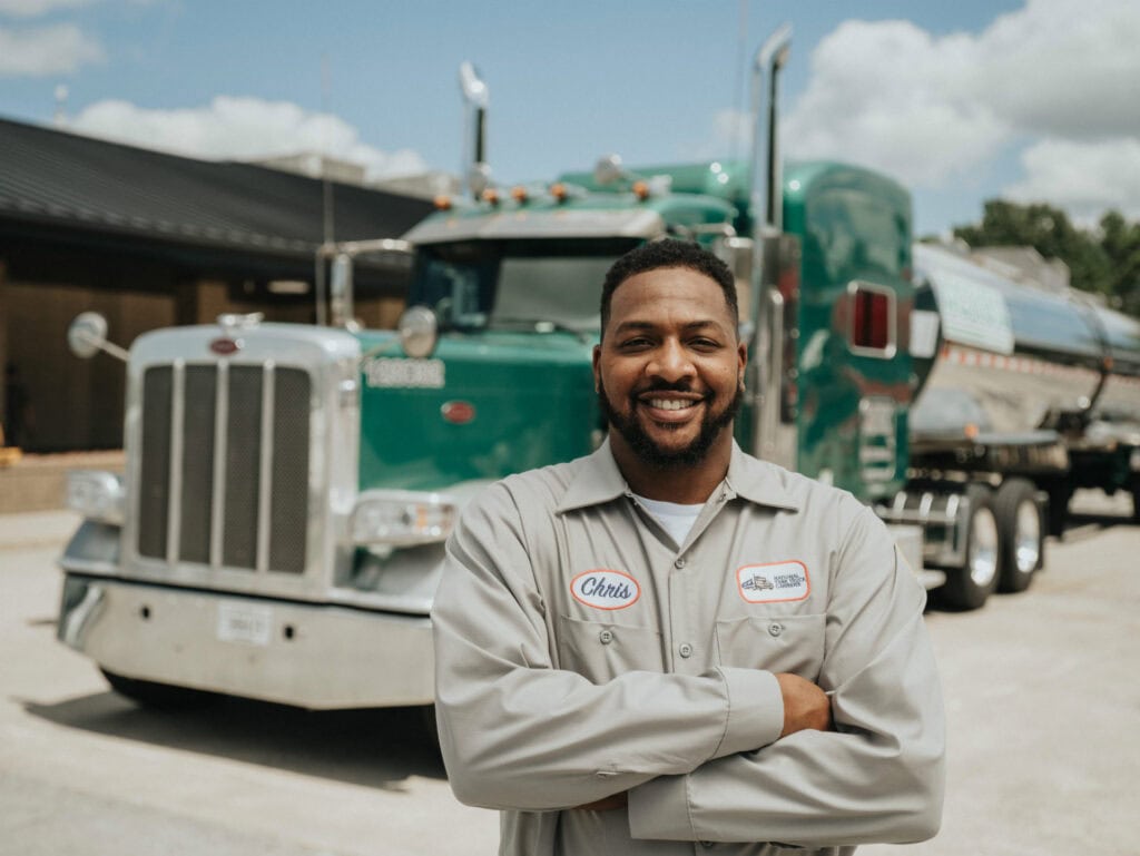 A man smiling in front of a truck