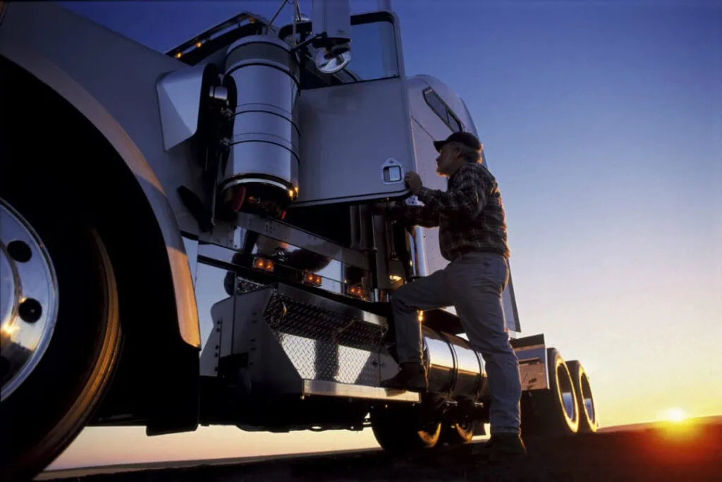 Closeup of a truck driver who is getting into a truck