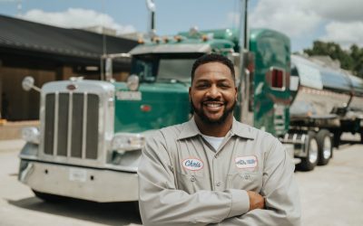 A man smiling in front of a truck