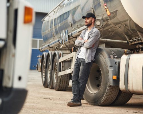 leaning-on-the-vehicle-young-truck-driver-in-casu-2023-11-27-05-09-06-utc-w1080-h1920